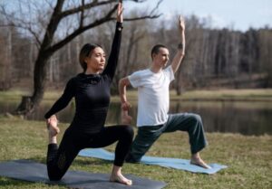 a man and woman doing yoga outside