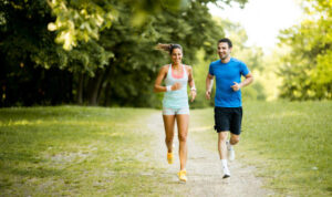 a man and woman running on a path